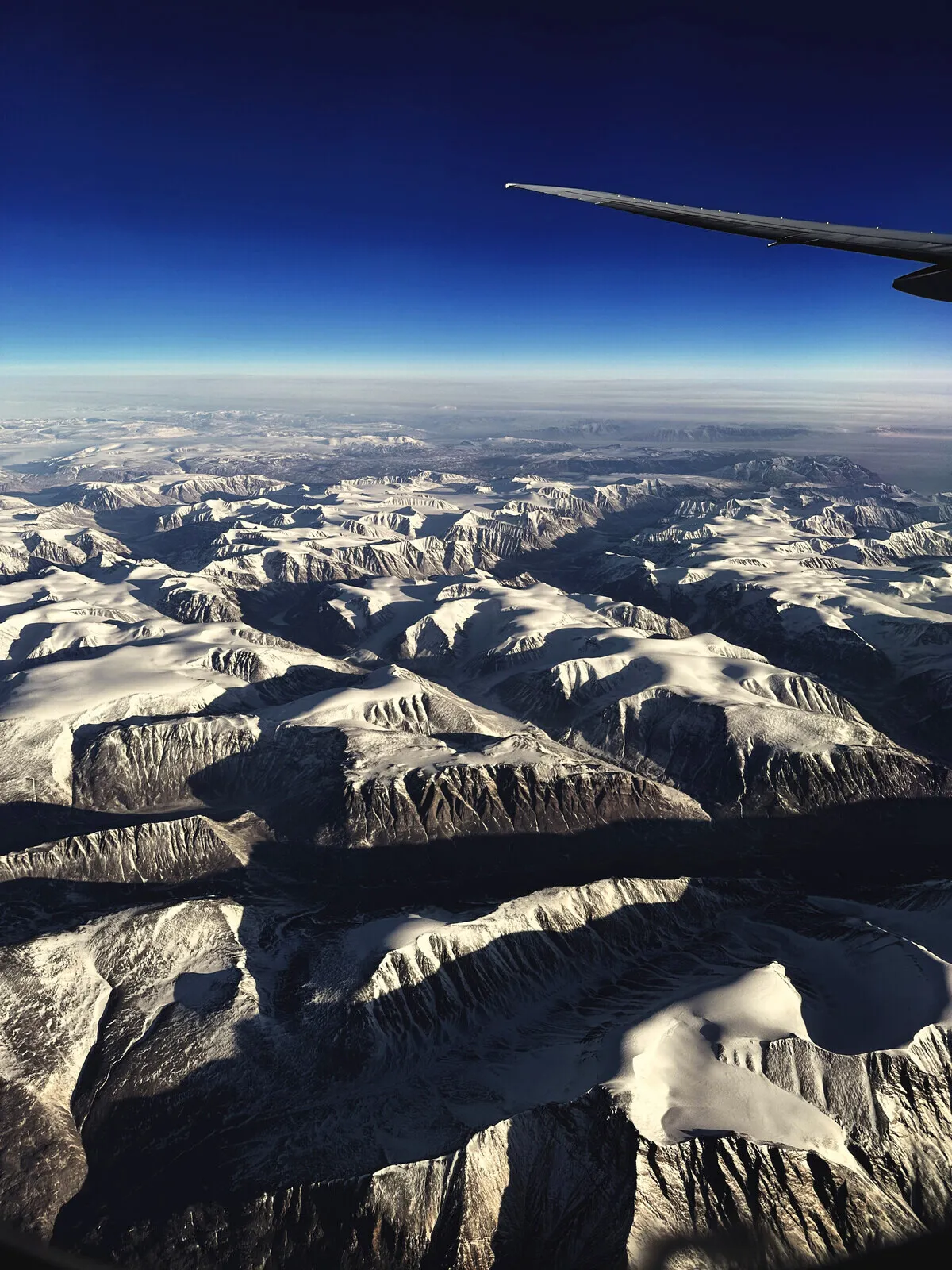 Snow-covered mountains from an aircraft window.