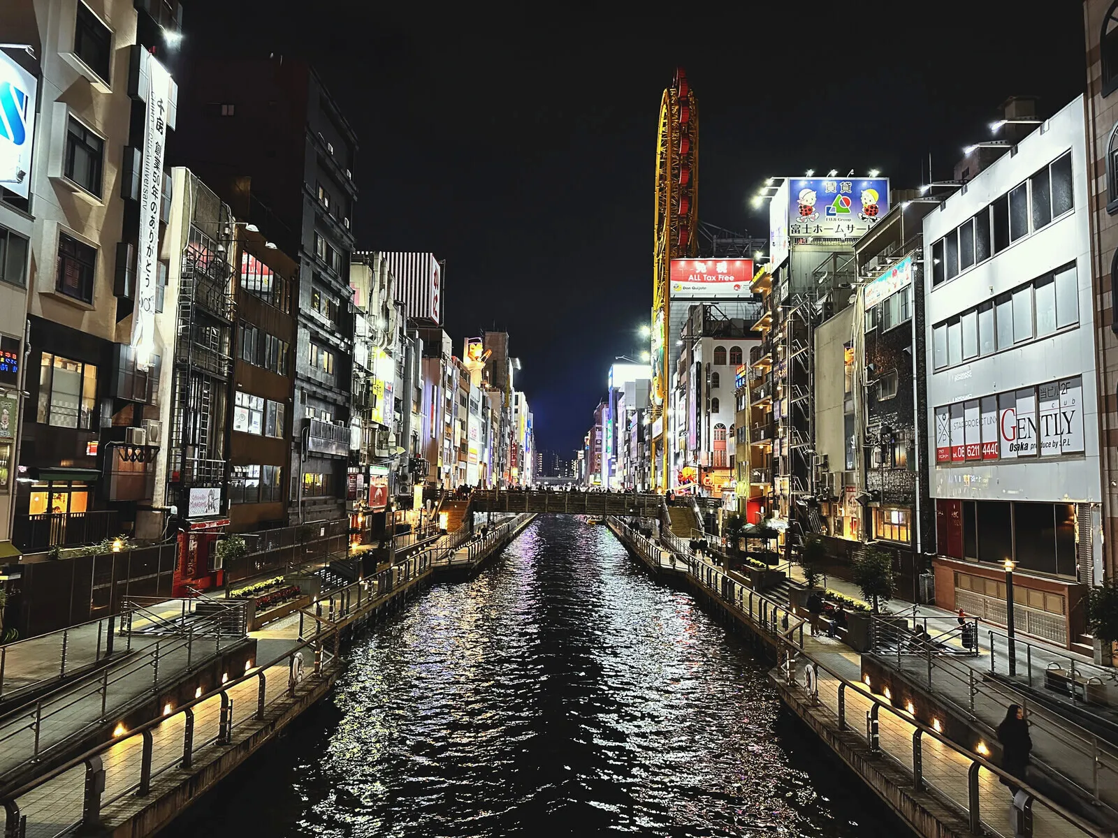 The Dōtonbori canal in Osaka at night, signs lit on both banks.