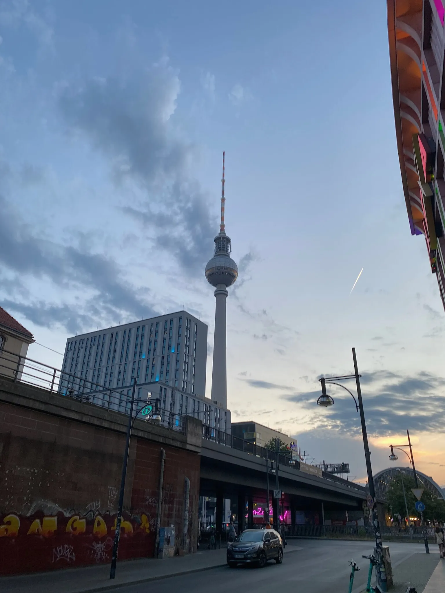 The television tower at dusk, above a railway viaduct.