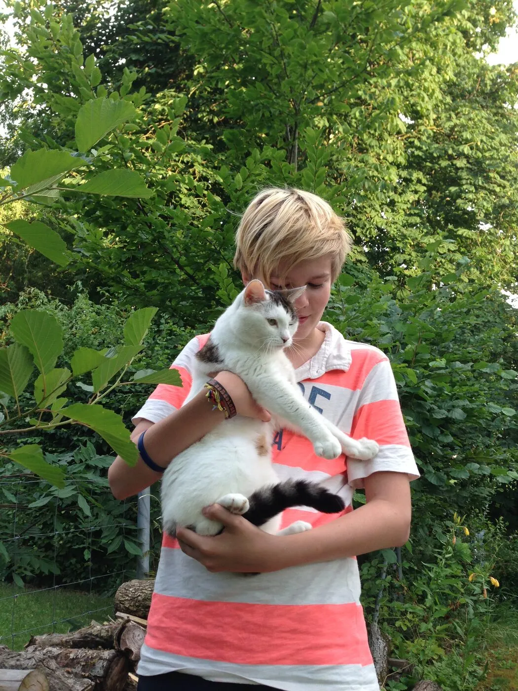 Holding a cat in the garden as a boy.