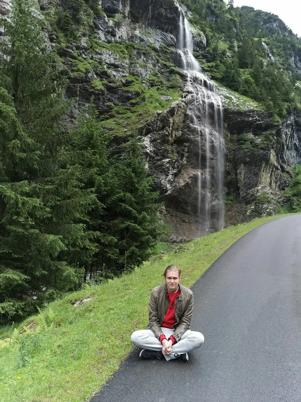 Sitting on a road in front of a waterfall.